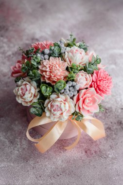 Hediye silindirik karton bir kutuda güzel, parlak gül çiçekleri. Bir buket sabun çiçeği.