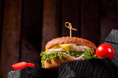 Marul ve peynirli ev yapımı hamburger. Ev yapımı hamburgerler ahşap masada.