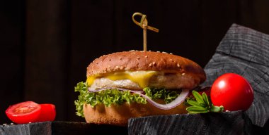 Marul ve peynirli ev yapımı hamburger. Ev yapımı hamburgerler ahşap masada.