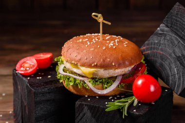 Marul ve peynirli ev yapımı hamburger. Ev yapımı hamburgerler ahşap masada.