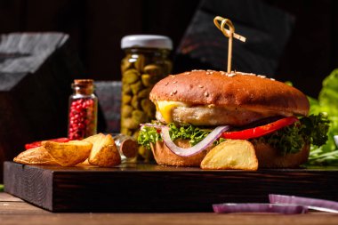 Marul ve peynirli ev yapımı hamburger. Ev yapımı hamburgerler ahşap masada.