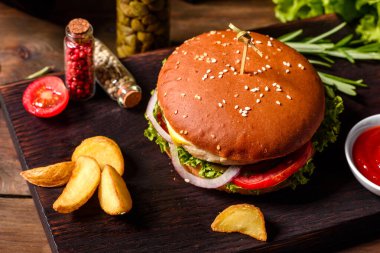 Marul ve peynirli ev yapımı hamburger. Ev yapımı hamburgerler ahşap masada.