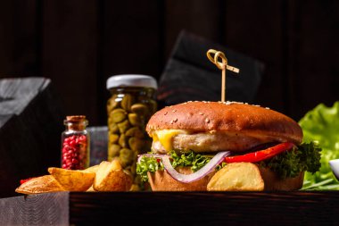 Marul ve peynirli ev yapımı hamburger. Ev yapımı hamburgerler ahşap masada.
