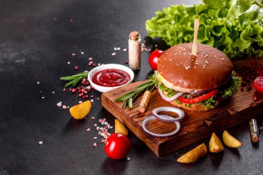 Marul ve peynirli ev yapımı hamburger. Ev yapımı hamburgerler ahşap masada.