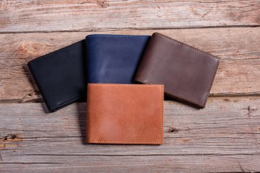 Ahşap zemin üzerinde para ve kutu olan şık deri cüzdan.
