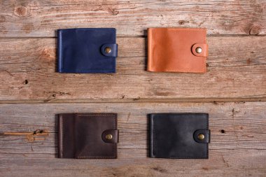 Ahşap zemin üzerinde para ve kutu olan şık deri cüzdan.