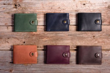 Ahşap zemin üzerinde para ve kutu olan şık deri cüzdan.
