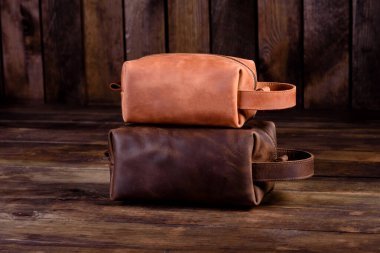 Deri kayışlı eski bir deri çanta. Tahta bir arka planda güzel, küçük, deri bir kadın çantası.