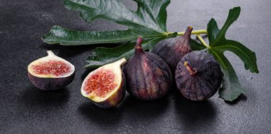 Karanlık masada taze incir var. Sağlıklı Akdeniz incir meyvesi. Siyah arkaplanda taze incir