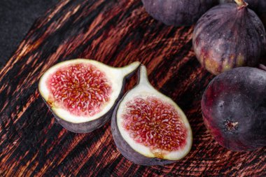 Karanlık masada taze incir var. Sağlıklı Akdeniz incir meyvesi. Siyah arkaplanda taze incir