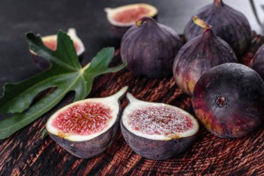 Karanlık masada taze incir var. Sağlıklı Akdeniz incir meyvesi. Siyah arkaplanda taze incir