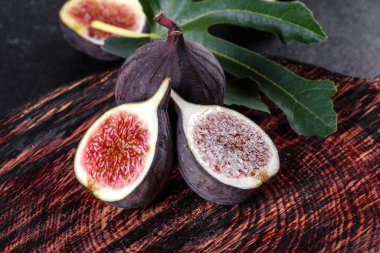 Karanlık masada taze incir var. Sağlıklı Akdeniz incir meyvesi. Siyah arkaplanda taze incir