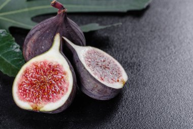 Karanlık masada taze incir var. Sağlıklı Akdeniz incir meyvesi. Siyah arkaplanda taze incir