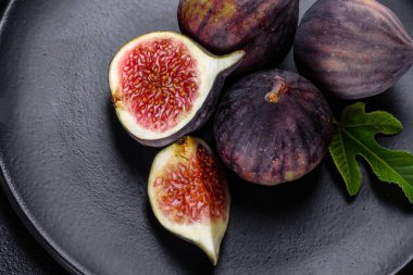 Karanlık masada taze incir var. Sağlıklı Akdeniz incir meyvesi. Siyah arkaplanda taze incir