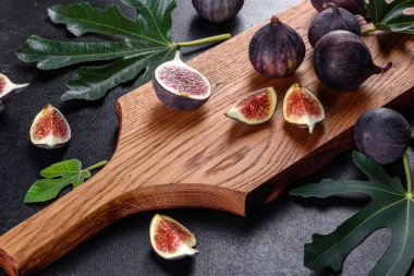 Karanlık masada taze incir var. Sağlıklı Akdeniz incir meyvesi. Siyah arkaplanda taze incir