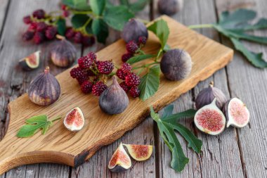 Karanlık bir arka planda taze incir ve böğürtlen. Böğürtlen ve meyve topluyorum.