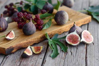 Karanlık bir arka planda taze incir ve böğürtlen. Böğürtlen ve meyve topluyorum.