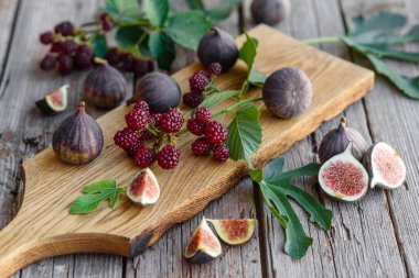 Karanlık bir arka planda taze incir ve böğürtlen. Böğürtlen ve meyve topluyorum.