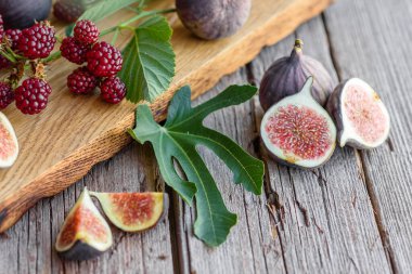 Karanlık bir arka planda taze incir ve böğürtlen. Böğürtlen ve meyve topluyorum.
