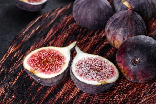 Karanlık masada taze incir var. Sağlıklı Akdeniz incir meyvesi. Siyah arkaplanda taze incir