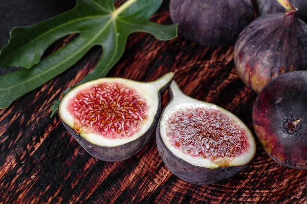 Karanlık masada taze incir var. Sağlıklı Akdeniz incir meyvesi. Siyah arkaplanda taze incir