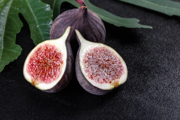 Karanlık masada taze incir var. Sağlıklı Akdeniz incir meyvesi. Siyah arkaplanda taze incir