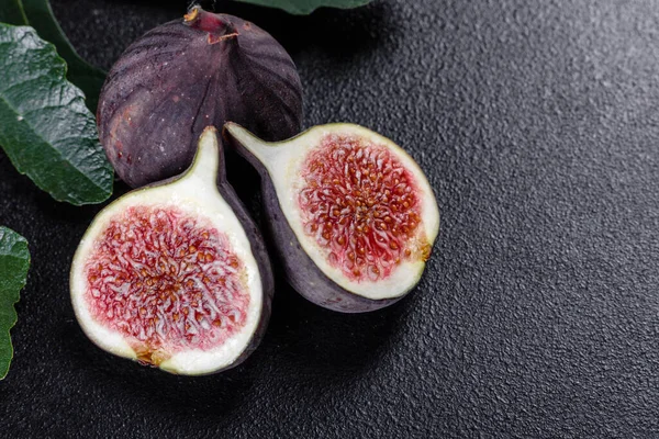 Karanlık masada taze incir var. Sağlıklı Akdeniz incir meyvesi. Siyah arkaplanda taze incir