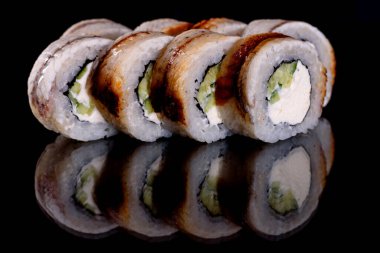 Karanlık bir arka planda taze, lezzetli suşi ruloları. Japon mutfağının elementleri