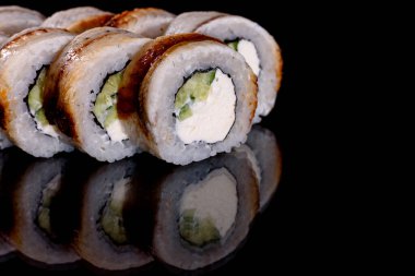 Karanlık bir arka planda taze, lezzetli suşi ruloları. Japon mutfağının elementleri