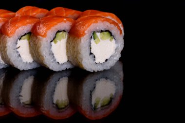 Karanlık bir arka planda taze, lezzetli suşi ruloları. Japon mutfağının elementleri