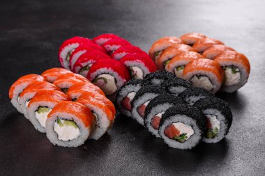Karanlık bir arka planda taze, lezzetli suşi ruloları. Japon mutfağının elementleri
