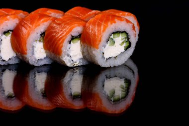 Karanlık bir arka planda taze, lezzetli suşi ruloları. Japon mutfağının elementleri