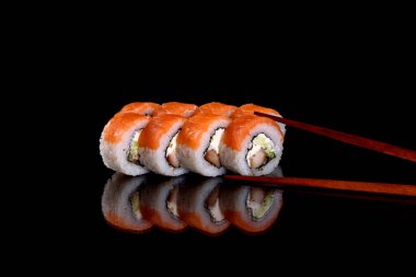 Karanlık bir arka planda taze, lezzetli suşi ruloları. Japon mutfağının elementleri