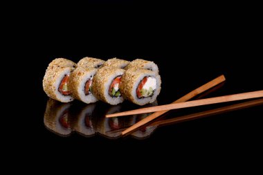 Karanlık bir arka planda taze, lezzetli suşi ruloları. Japon mutfağının elementleri