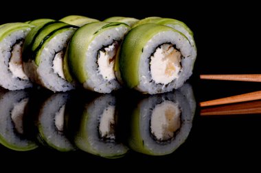 Karanlık bir arka planda taze, lezzetli suşi ruloları. Japon mutfağının elementleri