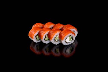 Karanlık bir arka planda taze, lezzetli suşi ruloları. Japon mutfağının elementleri