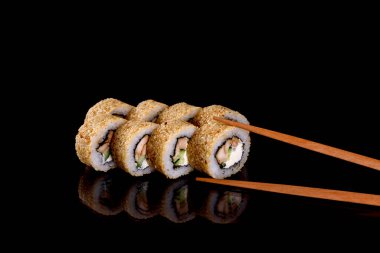 Karanlık bir arka planda taze, lezzetli suşi ruloları. Japon mutfağının elementleri