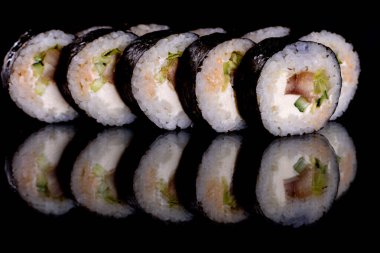 Karanlık bir arka planda taze, lezzetli suşi ruloları. Japon mutfağının elementleri