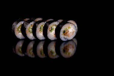 Karanlık bir arka planda taze, lezzetli suşi ruloları. Japon mutfağının elementleri
