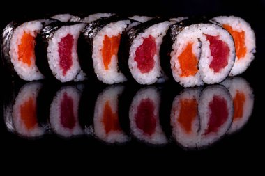 Karanlık bir arka planda taze, lezzetli suşi ruloları. Japon mutfağının elementleri