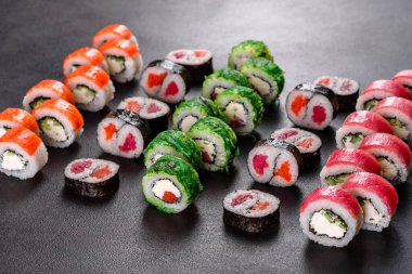 Karanlık bir arka planda taze, lezzetli suşi ruloları. Japon mutfağının elementleri