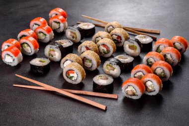 Karanlık bir arka planda taze, lezzetli suşi ruloları. Japon mutfağının elementleri