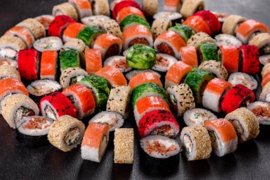 Karanlık bir arka planda taze, lezzetli suşi ruloları. Japon mutfağının elementleri