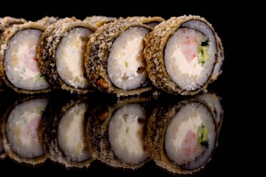 Karanlık bir arka planda taze, lezzetli suşi ruloları. Japon mutfağının elementleri