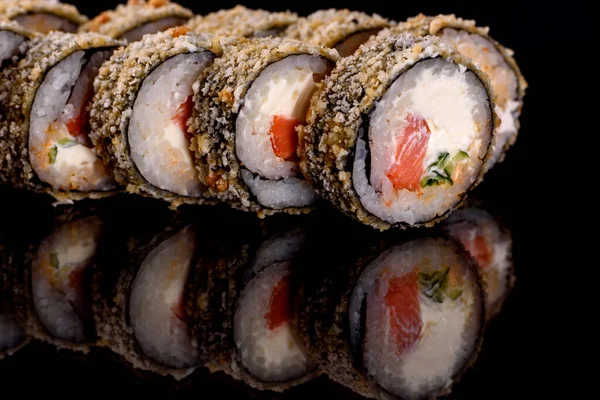 Karanlık bir arka planda taze, lezzetli suşi ruloları. Japon mutfağının elementleri