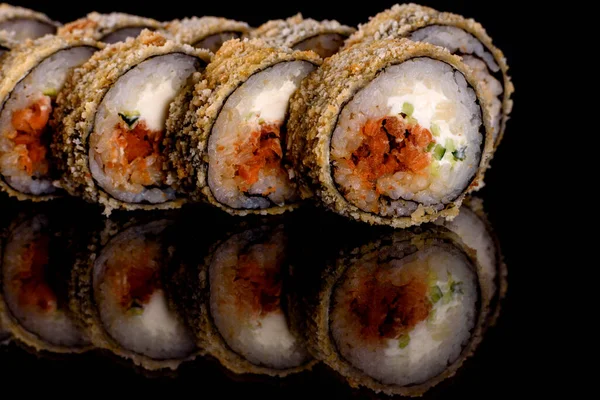 Karanlık bir arka planda taze, lezzetli suşi ruloları. Japon mutfağının elementleri
