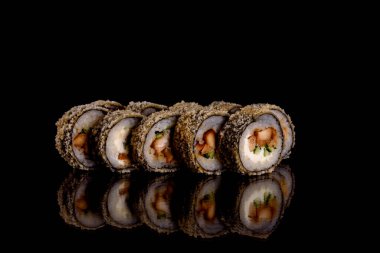 Karanlık bir arka planda taze, lezzetli suşi ruloları. Japon mutfağının elementleri
