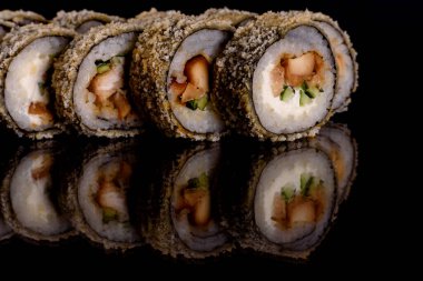 Karanlık bir arka planda taze, lezzetli suşi ruloları. Japon mutfağının elementleri