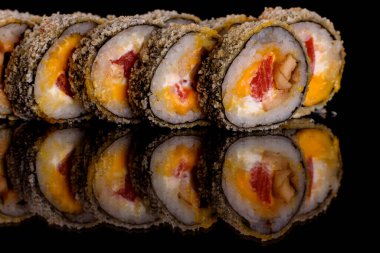 Karanlık bir arka planda taze, lezzetli suşi ruloları. Japon mutfağının elementleri