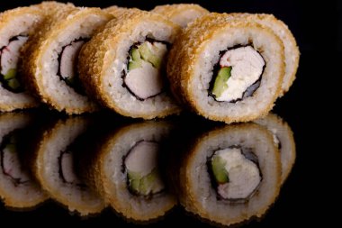 Karanlık bir arka planda taze, lezzetli suşi ruloları. Japon mutfağının elementleri